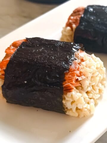 Prepared salmon musubi on a white tray