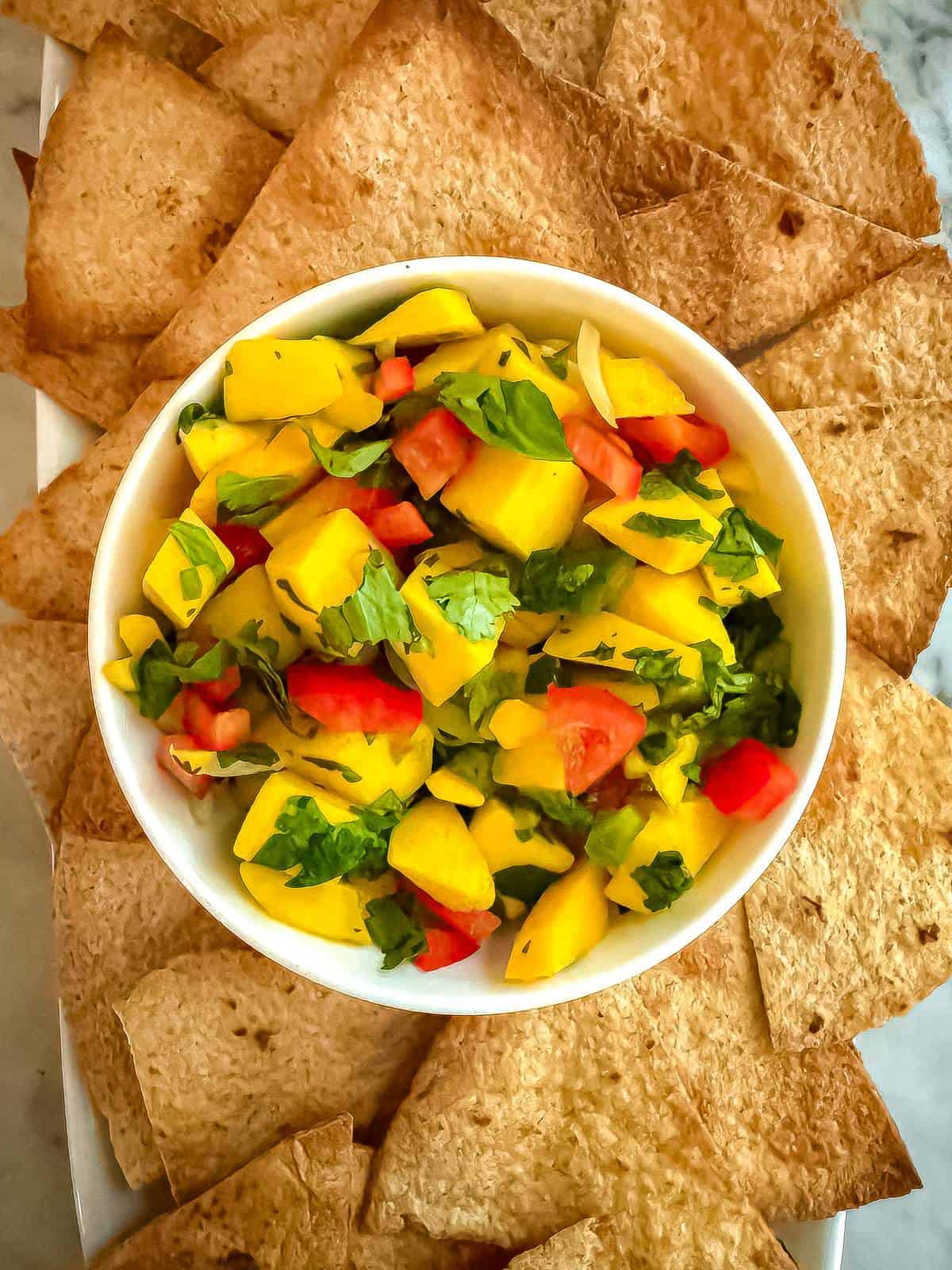 whole wheat tortilla chips with a bowl of mango jalapeno salsa