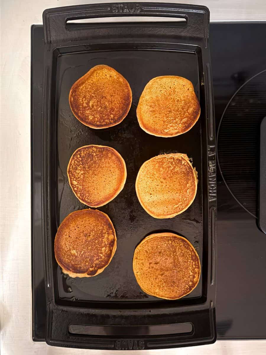 Mediterranean Diet Kodiak Pumpkin Pancakes cooked golden brown on a cast iron griddle.