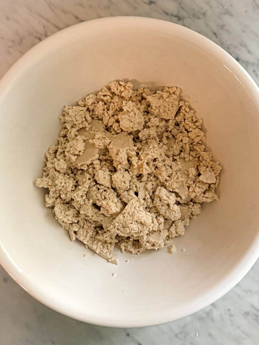 Pressed tofu crumbled in a bowl.