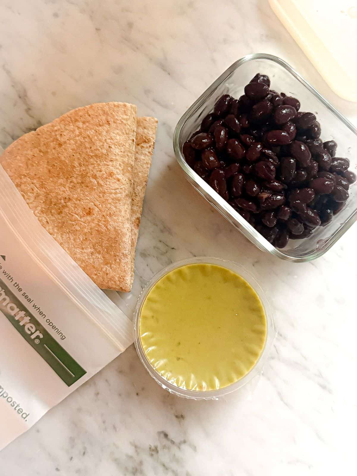 Easy Vegan Taco recipe for lunch prep to take on the go. Whole wheat tortilla, guacamole, black beans.