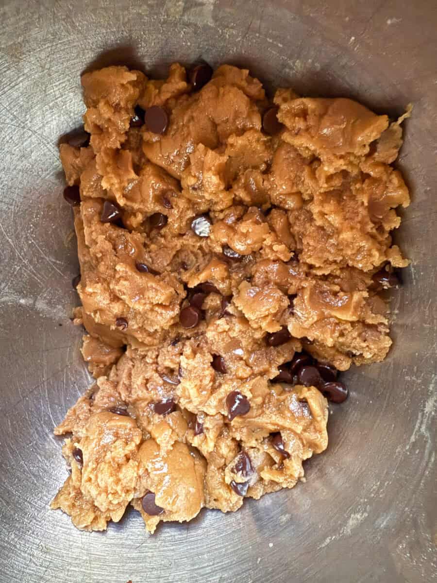 Dairy free chocolate chip cookie dough in a silver mixing bowl