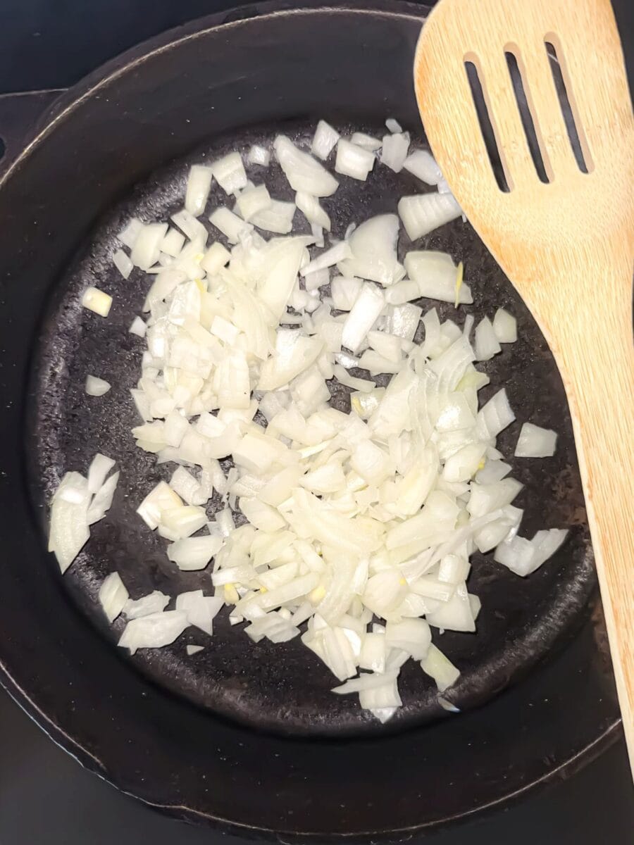 Onions being cooked in a cast iron skillet