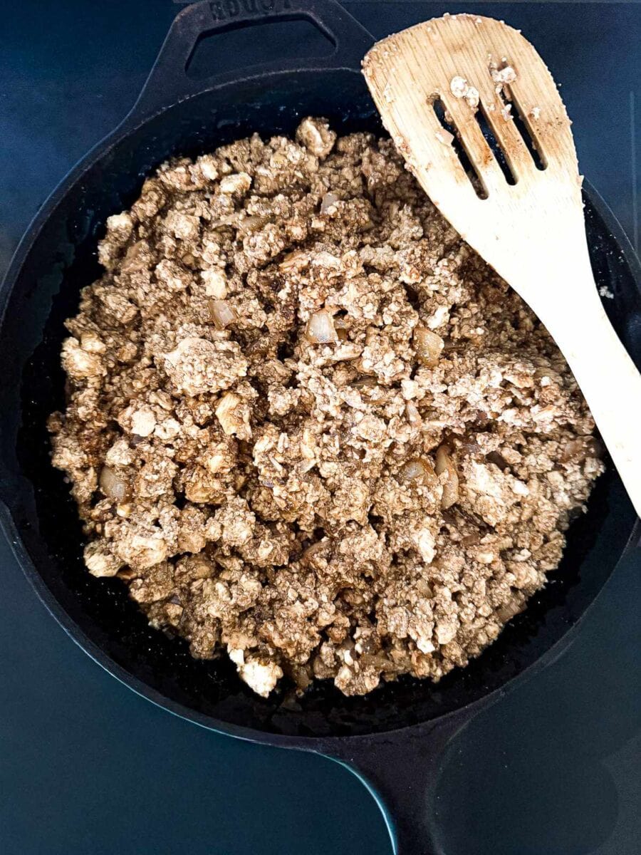 Tofu with a brown sauce for tofu lettuce wraps in a cast iron skillet