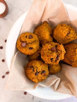 Freshly baked Mediterranean Diet Kodiak Pumpkin Muffins with chocolate chips in a white bowl.