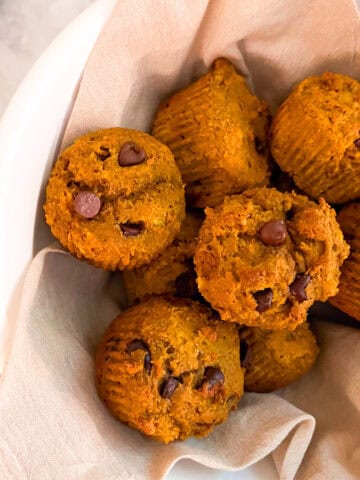 Freshly baked Mediterranean Diet Kodiak Pumpkin Muffins with chocolate chips in a white bowl.