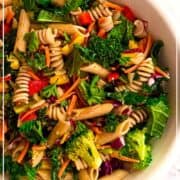 Mediterranean Pasta Salad featuring kale, whole grain pasta, EVOO, tomatoes, cucumbers, carrots, broccoli and wholesome ingredients. Salad is in a bowl on a marble counter. Text overlap says Healthy Mediterranean Diet Pasta Salad and the Mediterranean for Life logo is shown.