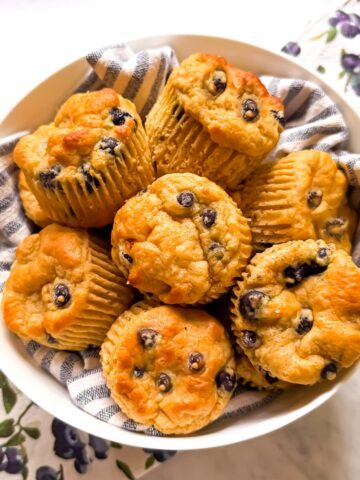 A bowl of high protein blueberry muffins. Mediterranean Diet friendly with whole grains, EVOO, and fresh blueberries.