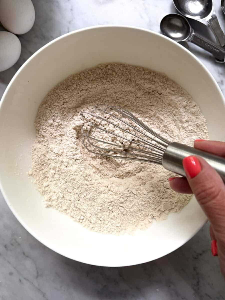 Dry ingredients for high protein blueberry muffins mixed together in a bowl. Includes Kodiak power cakes flapjack & waffle mix, sugar, salt, baking soda and baking powder.