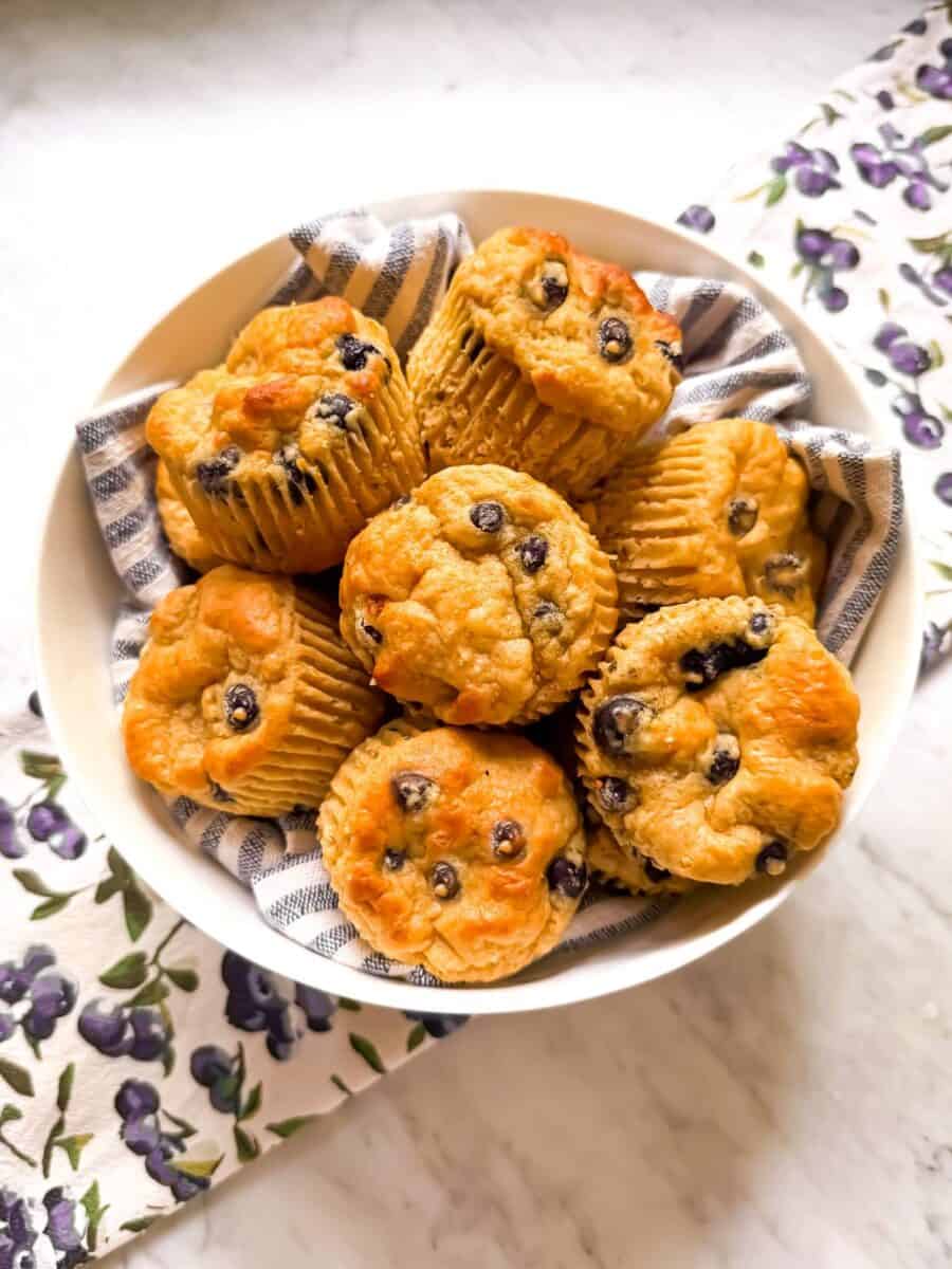 A bowl of high protein blueberry muffins. Mediterranean Diet friendly with whole grains, EVOO, and fresh blueberries.
